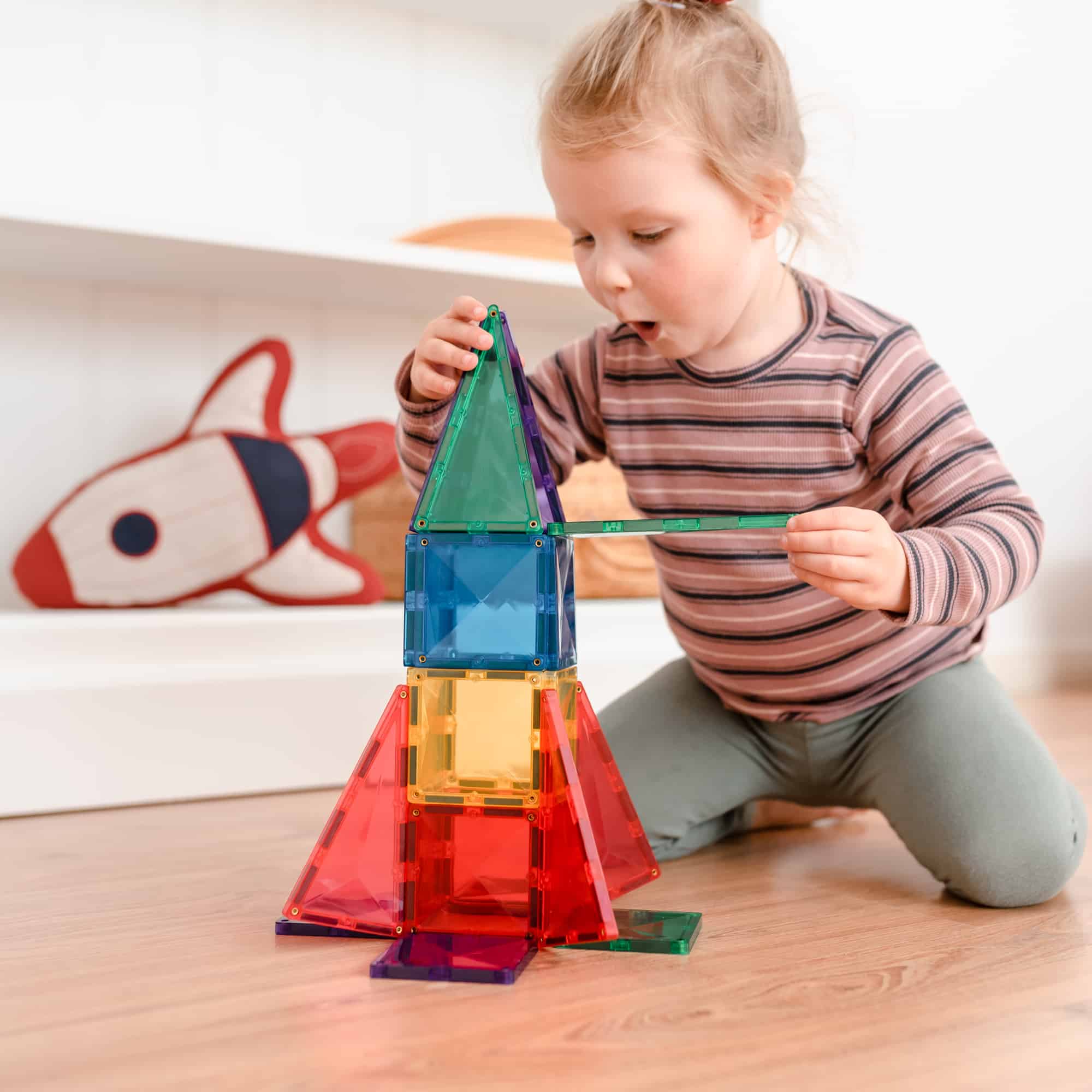 Child playing with the connetix 62 pc starter pack rainbow