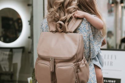 Mum with nappy backpack oat dimple on her back carrying a child