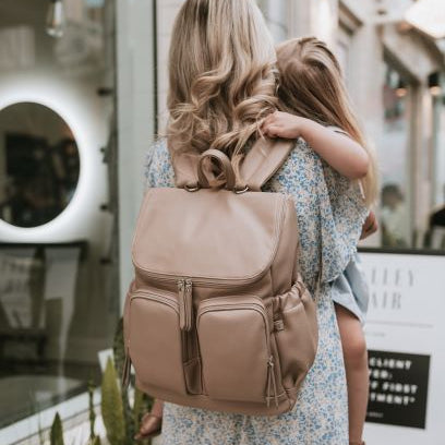 Mum with nappy backpack oat dimple on her back carrying a child