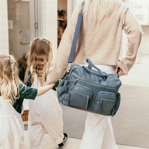 mum carrying the carry all nappy bag in stone blue
