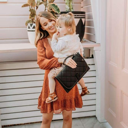 Mum holding baby and change mat clutch in black