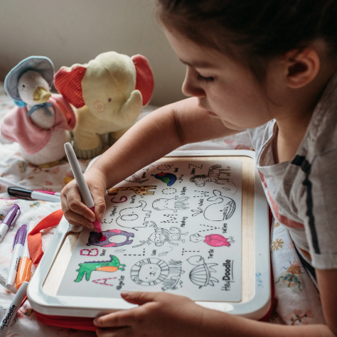 kid drawing on a hey doodle reusable mat