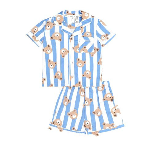 A two-piece children's pajama set featuring a short-sleeve button-up top and matching shorts, printed with vertical light blue and white stripes and a repeating pattern of cartoon teddy bears, shown on a plain white background.