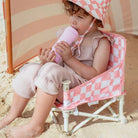 Toddler at the beach sitting in the baby camping chair