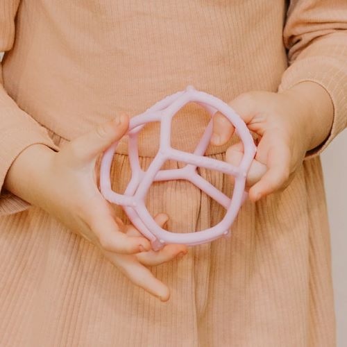 little girl holding a sensory ball in bubblegum