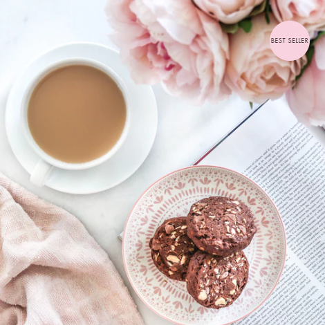 Made to milk triple chocoholic lactation cookies on a plate with a cup of tea.