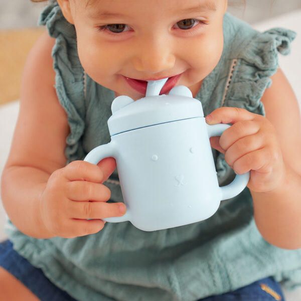 Child drinking from mini sippi bear cup with handles