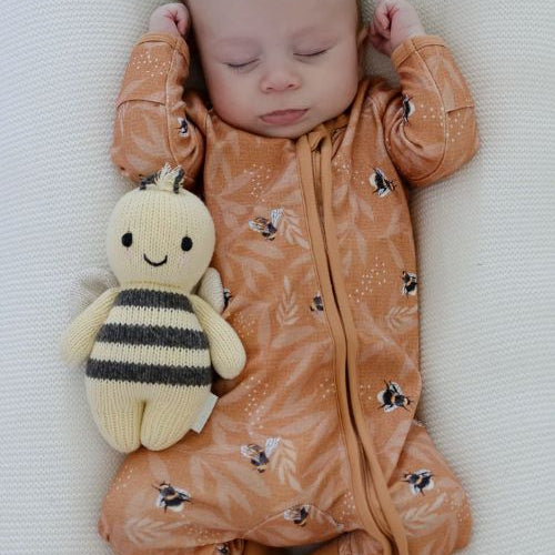 Baby sleeping wearing bamboo zipsuit in bumble bee print