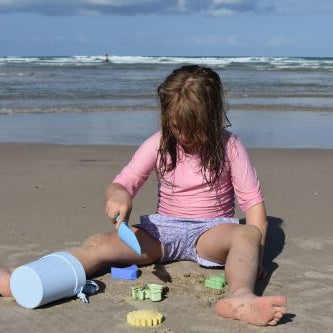 Little girl playing with the beach set on the beach