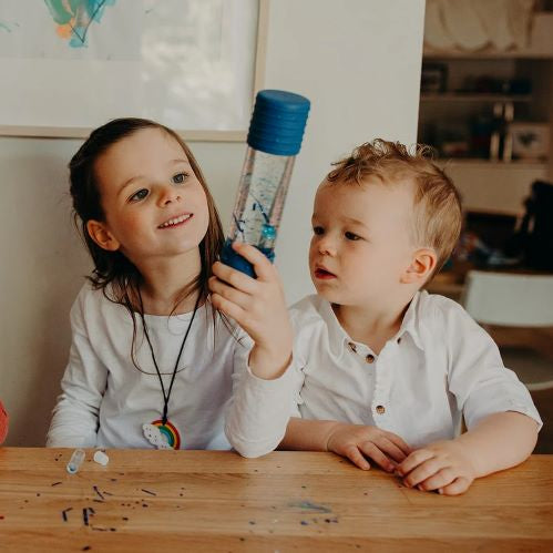 Kids playing with a DIY calm down bottle blue