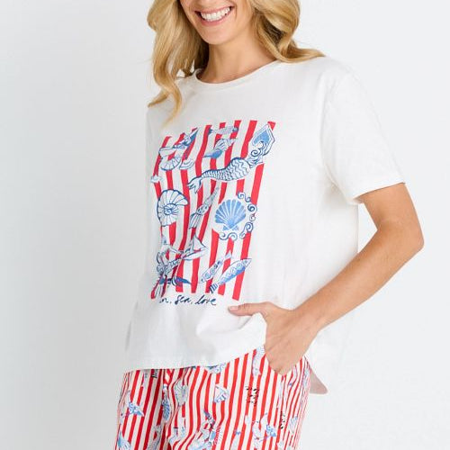 Woman wearing a white t-shirt with a red and blue graphic and a matching skirt on a white background