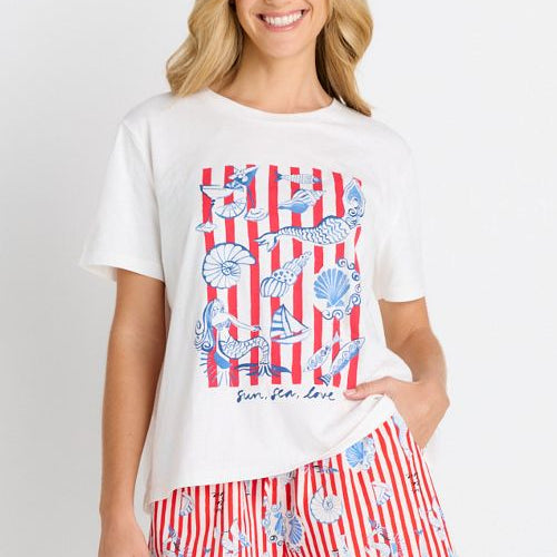 A woman modeling a white graphic t-shirt and matching red, white, and blue striped swim shorts against a plain white background.