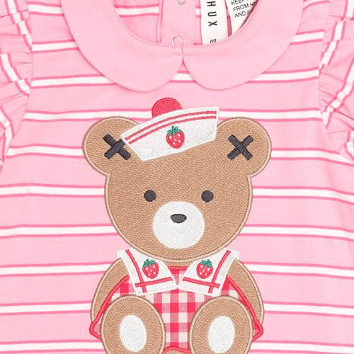Pink and white striped baby t-shirt with a teddy bear applique wearing a nurse hat and red gingham overalls, featuring a Peter Pan collar and ruffled sleeves.