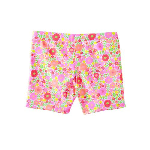A pair of girls' swim shorts featuring a vibrant, dense floral pattern in pink, orange, green, and red on a light pink base, shown flat against a white background.