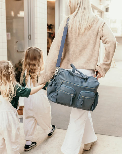 mum carrying the carry all nappy bag in stone blue