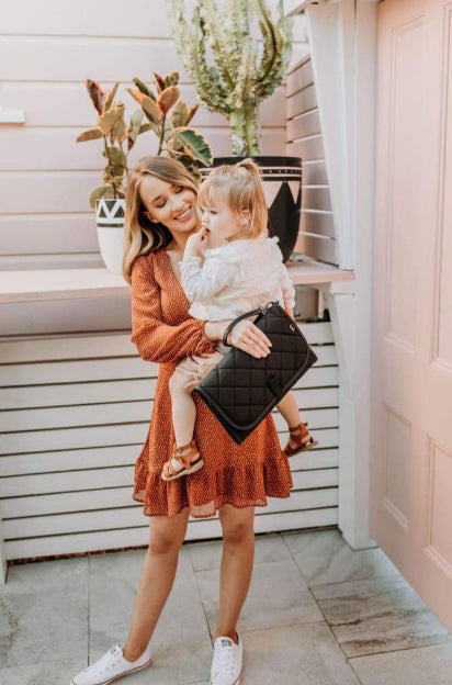 Mum holding baby and change mat clutch in black