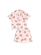 A two-piece children's pajama set featuring a short-sleeve button-up shirt and matching shorts, both with pink and white vertical stripes and an all-over print of brown teddy bear faces, shown on a plain white background.
