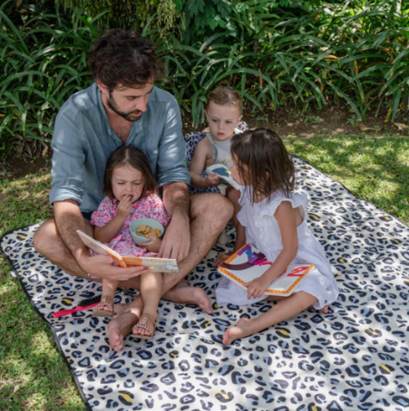 Helio Picnic Mat with family sitting reading a book