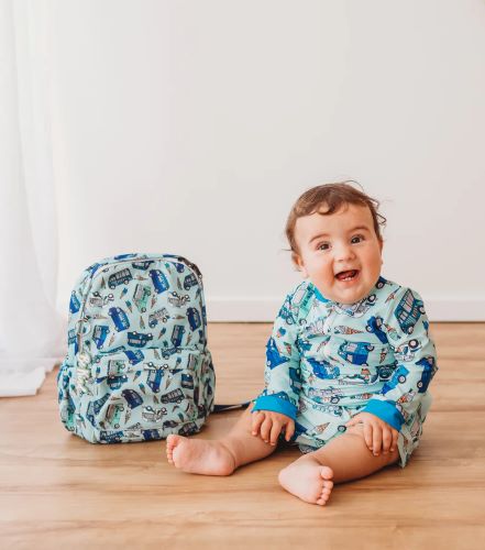 Toddler sitting next to mini backpack in mr ice-cream print