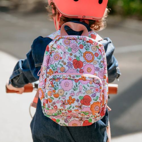 Toddler riding a bike wearing the Paloma mini backpack