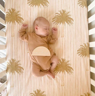 Baby sleeping on a stripe palm cot sheet set