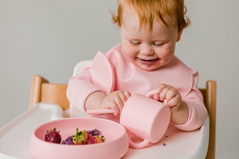 Toddler using the suckie scoop plate