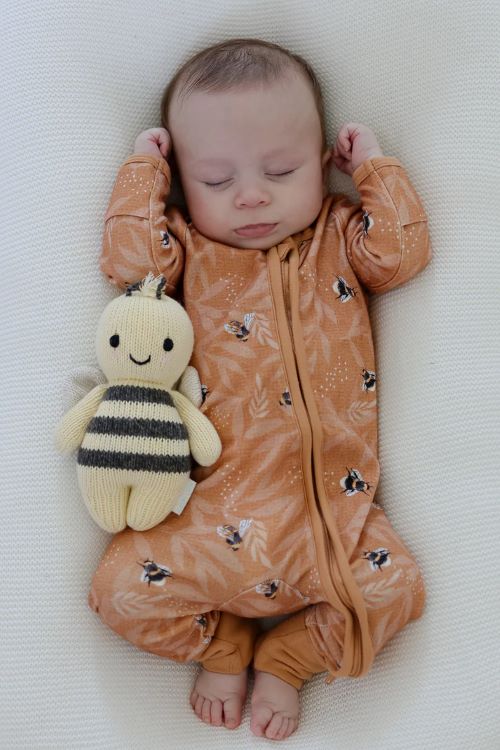 Baby sleeping wearing bamboo zipsuit in bumble bee print