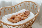 Baby in bassinet wearing bamboo zipsuit in bumble bee print