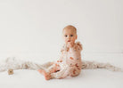 Baby wearing bamboo zipsuit in classic fawn print