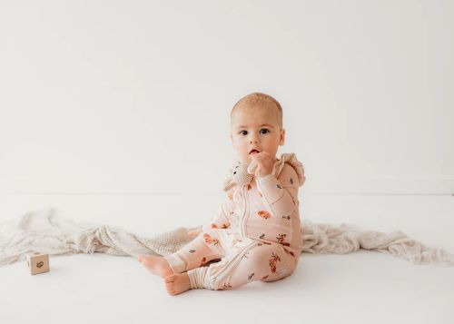 Baby wearing bamboo zipsuit in classic fawn print