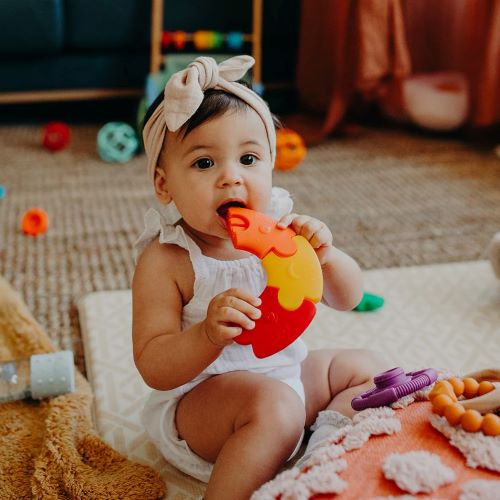 Baby Girl playing with colour wheel rainbow bright