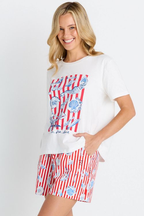 Woman wearing a white t-shirt with a red and blue graphic and a matching skirt on a white background