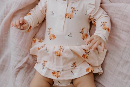 Baby wearing onesie flutter dress in classic fawn