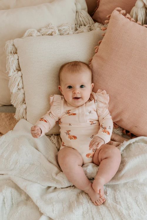 BAby wearing frilly bodysuit in classic fawn print