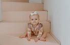 Toddler wearing frilly bodysuit in vintage teddies print