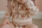 Baby wearing frilly bodysuit in vintage teddie print