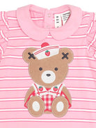 Pink and white striped baby t-shirt with a teddy bear applique wearing a nurse hat and red gingham overalls, featuring a Peter Pan collar and ruffled sleeves.