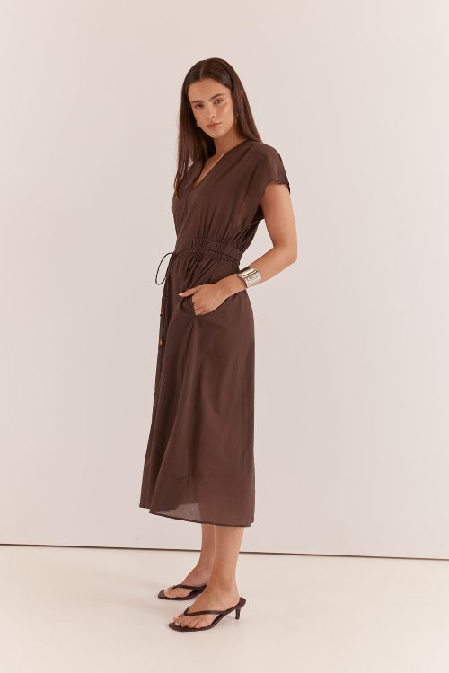 Woman wearing a brown dress against a white background