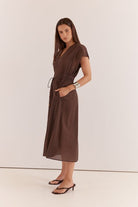 Woman wearing a brown dress against a white background