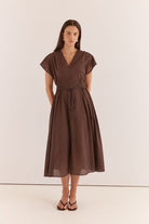 Woman wearing a brown dress against a white background