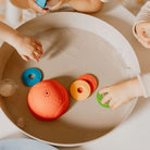 Children playing with ocean stacking cups in a tub