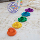 rainbow stacker and teether toy on a playmat