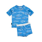 A two-piece kids' swim outfit featuring a short-sleeve rash guard top and matching swim trunks in bright blue, both printed with white fish illustrations and small orange accents. The trunks have a white elastic waistband with white drawstrings.