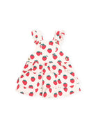 A baby girl's tiered overall dress featuring a red strawberry print on a warm cream background, with ruffled shoulder straps and a button closure.