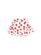 A white ruffled skirt with an all-over red strawberry print, laid flat against a solid white background.