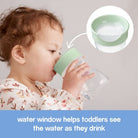 baby using b.box training cup to show the water window.