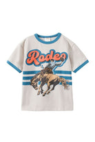 A kids' short-sleeve ringer t-shirt in off-white, featuring a blue collar and sleeve trim, with a graphic print of a cowboy on a bucking horse and the word 'Rodeo' in orange and blue.
